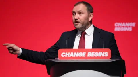 EPA Ian Murray, dressed in a suit, speaking at the Labour party conference. He is pointing off camera.