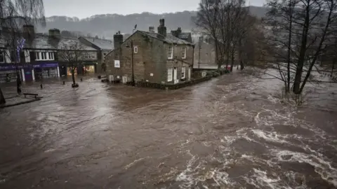 PA Media Houses and shops are surrounded by flood waters in Hebden Bridge.