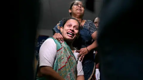 AFP via Getty Images Relatives mourn as they await DNA sample tests, for their loved ones to be identified, at an emergency centre in Ahmedabad on June 13, 2025, a day after Air India flight 171 crashed in a residential area. Rescue teams with sniffer dogs combed the crash site on June 13 of a London-bound passenger jet which ploughed into a residential area of India's Ahmedabad city, killing at least 265 people on board and on the ground. (Photo by Punit PARANJPE / AFP) (Photo by PUNIT PARANJPE/AFP via Getty Images)