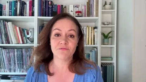 Woman with brown hair in a blue shirt.