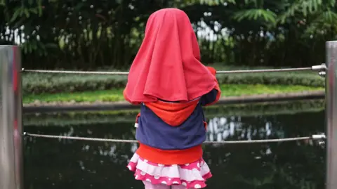 File photo of a Muslim girl looking at the pond