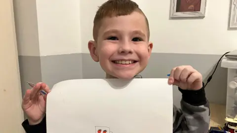 BBC Corey holds up a picture