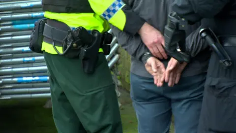 Police officer handcuffs man 