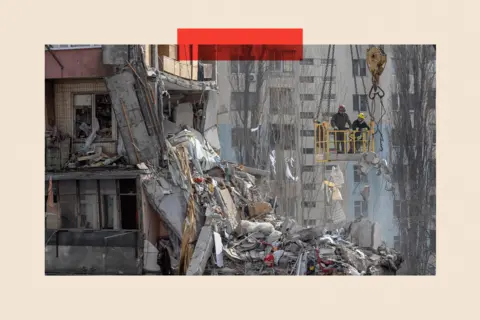 AFP via Getty Images Rescuers clear debris from a multi-story building heavily damaged following a drone strike, in Odesa 
