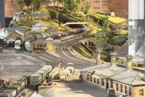 Derby Museums Model railway scene with trains and houses.