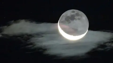 A cresent Moon, with the darker whole visible