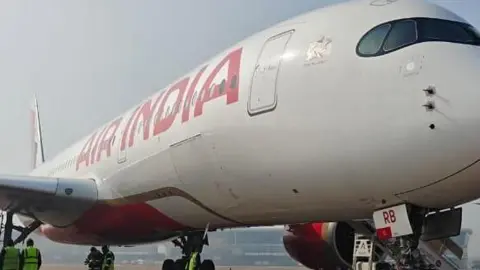 The Air India Airbus A350 in Delhi airport surrounded by ground crew after the engine damage on 15 January 2026