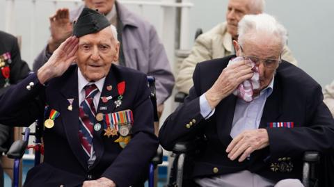 D-Day veteran Bernard Morgan (left), 100, from Crewe, salutes as veteran Harry Birdsall, 98, from Wakefield, gets emotional as he travels on the Brittany Ferries ship Mont St Michel