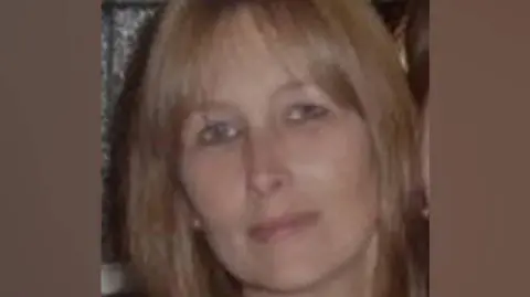 Devon and Cornwall Police The image shows a person with medium-length brown hair. The hair appears straight and falls around the sides of the head. 