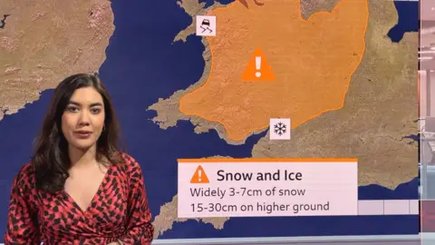 Sabrina Lee stands in front of a green screen with a map of Wales