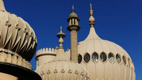 Getty Images The towers of Brighton Pavilion highlighted against a deep blue sky.