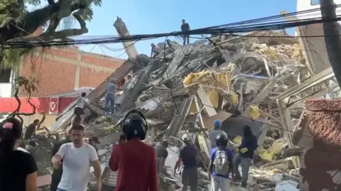 Reuters Rescue workers and residents stand around a collapsed building in the aftermath of an earthquake in Cali, Colombia, August 10, 2026 in this screengrab taken from a video.
