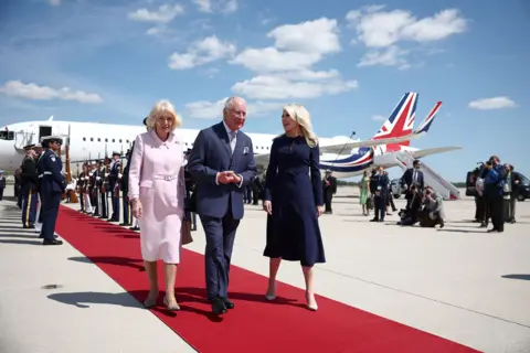 AFP via Getty Images Britain's King Charles III and Britain's Queen Camilla are greeted by US Protocol Chief Monica Crowley as they arrive at Joint Base Andrews, Maryland, on April 27, 2026.