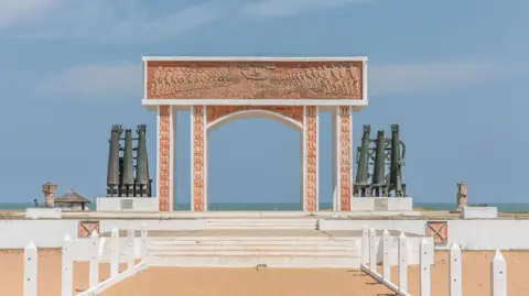 AFP / Getty Images A monument on a beach in Benin - a symbolic door frame, through which you can see the sea.