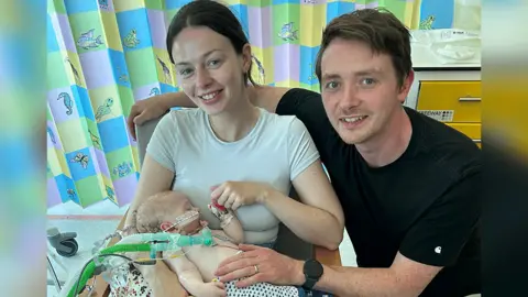 Family Photo Macs is being held by parents Catrin and Dylan Green while in hospital