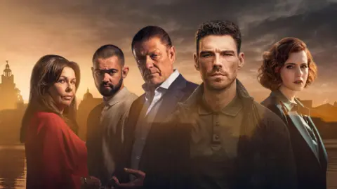 Key cast members shown against sunlit backdrop of Liverpool's waterfront including the Liver Building. They are Julie Graham who plays Elaine Phelan, Jack McMullen who plays Jamie Phelan, Sean Bean who plays Ronnie Phelan, James Nelson-Joyce who plays Michael Kavanagh, and Hannah Onslow who plays Diana Williams.