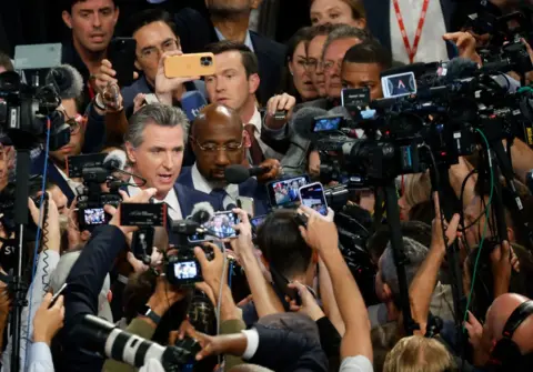 Getty California Governor Gavin Newsom and US Senator Raphael Warnock, both surrogates for the Biden campaign, are mobbed by press after the debate.
