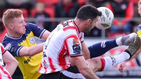 Shelbourne's Gavin Molloy attempts to clear the ball from Derry striker Pat Hoban