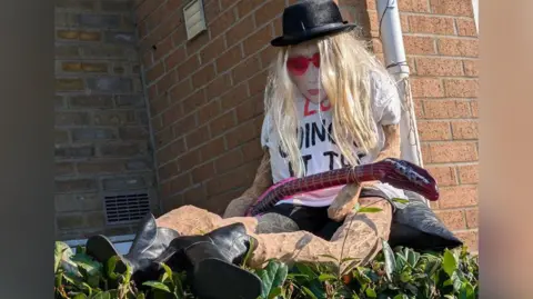 PA Images A replica of Taylor Swift has been made out of 22 hats and she is sitting on a hedge