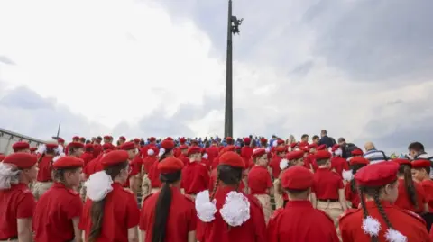 Children in Russia's Yunarmia stand in uniform, facing away from the camera