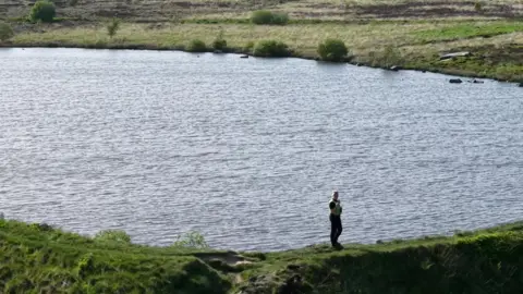 YappApp Police officer stands by a reservoir 