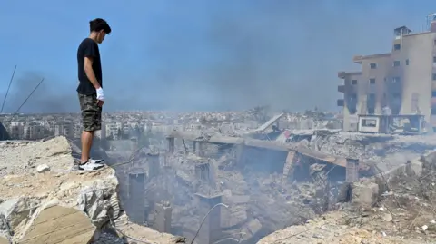 EPA A man looks at damage caused by an Israeli airstrike in Choueifat, southeast of Beirut, Lebanon, on September 28, 2024.