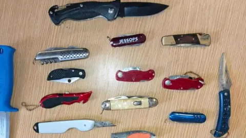 West Yorkshire Police A selection of knives handed in to police, including pen knives and a hunting knife.
