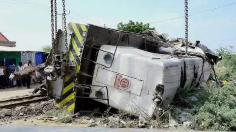 SRTV A train carriage lies on its side