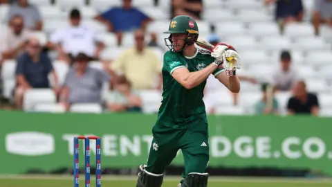 Lyndon James in the dark green kit of Notts Outlaws, plays a shot