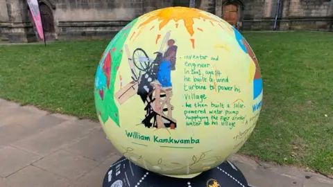 Mick Lunney/BBC A yellow coloured globe shows an image of an inventor.