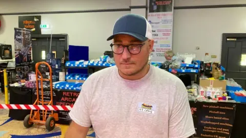 Martin Heath/BBC Craig Pullen with short dark hair wearing a blue and white cap and pink shirt