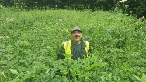 Friends of Brislington Brook  Andy McBride-Coogan among tall Himalayan Balsam plants 