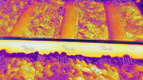 Network Rail Thermal image of railway tracks showing heat distribution across rails and ballast for monitoring track condition, with temperature readings 49–50C.