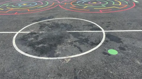 The middle of the Multi Use Games Area has a a large dark patch where the fire was