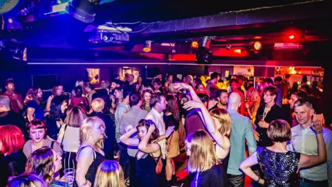 Pretty Ugly A packed nightclub floor, with dozens of people dancing away