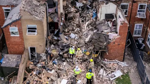 PA Media An aerial shot of debris and destroyed houses in Worksop. Workers are on site.