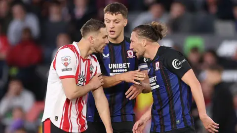 Taylor Harwood-Bellis and Luke Ayling clash during the play-off match at St Mary's