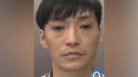 Police handout A mug shot of Xiao Long Lin. He has black hair, with a fringe covering his forehead. There is a West Midlands Police logo in the bottom right of the image.