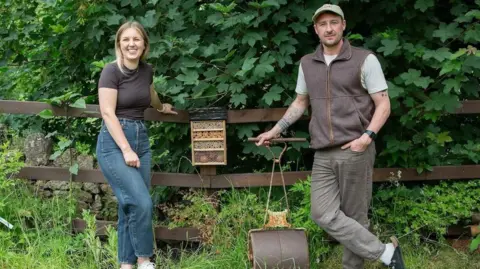 The Hop Pole Inn Two people stood next to a bug house