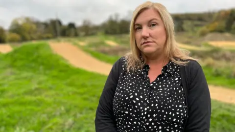 BBC Angela Ruskin photographed it on FlyUp 417 in Gloucestershire. Angela has long blonde hair and wears a black and white spotted blouse with a black cardigan. 