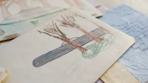 BBC/Twenty Twenty Productions Ltd Broad Haven Primary School children's drawings of UFOs on a table 