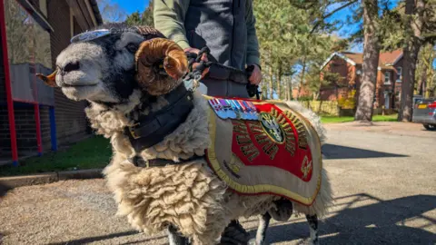 Private Derby being held by a companion 