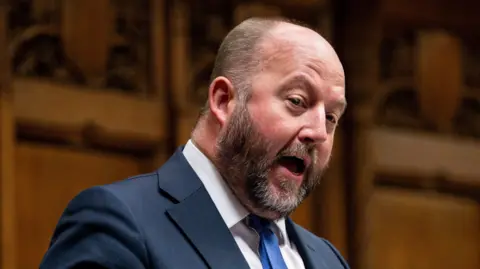 House of Commons Nick Timothy, a bearded man in a suit and tie, addresses the House of Commons