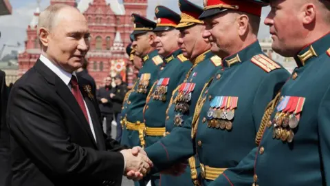 Putin shakes hands with participants in the Red Square military parade