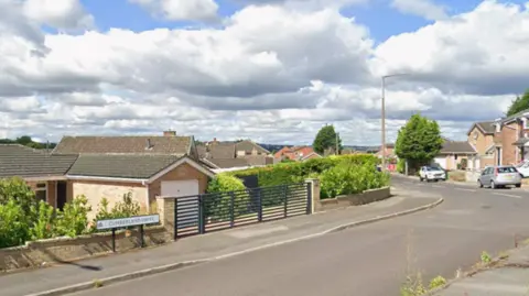A quiet housing estate with a road sign that reads Cumberland Drive