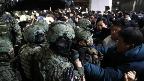 Soldiers in South Korea try to detain protesters during the imposition of martial law