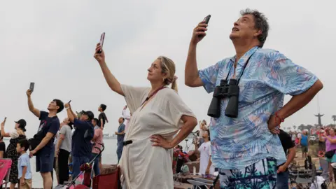 EPA viewers use their phones to record the starship launch