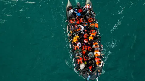 An overhead shot of a dinghy carrying migrants across the English Channel. 