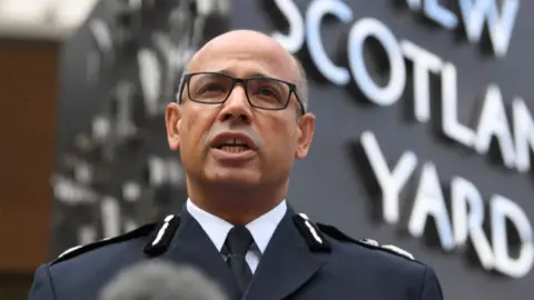 PA Media Former Assistant Commissioner Neil Basu speaking into a microphone outside Scotland Yard. 