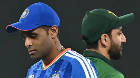 India's captain Suryakumar Yadav (L) walks past his Pakistan counterpart Salman Agha after the toss before the start of the 2026 ICC Men's T20 Cricket World Cup group stage match between India and Pakistan at the R Premadasa Stadium in Colombo 